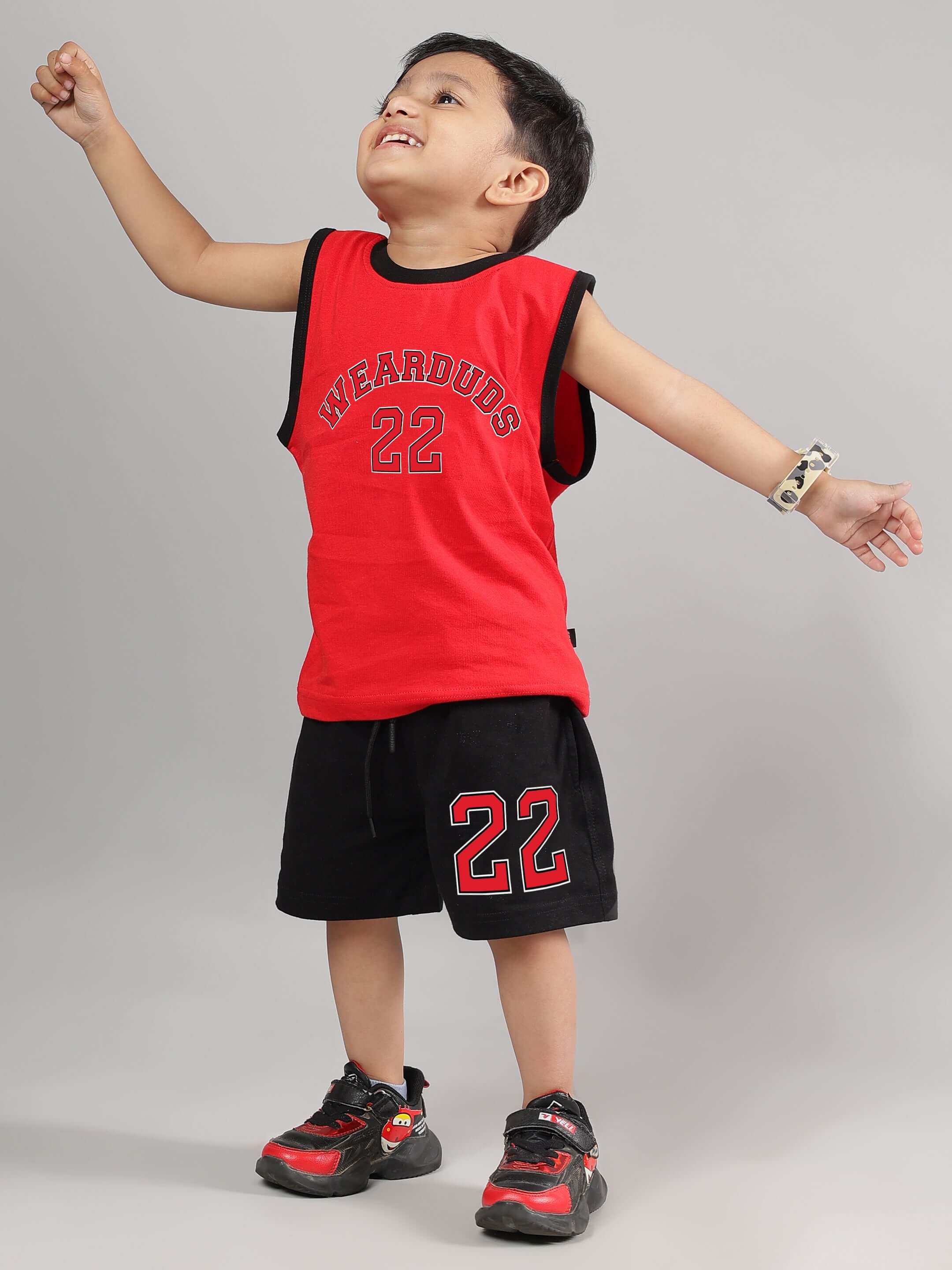Child wearing a red Amiga t-shirt for boys and girls, paired with black shorts, showcasing a playful and energetic pose.