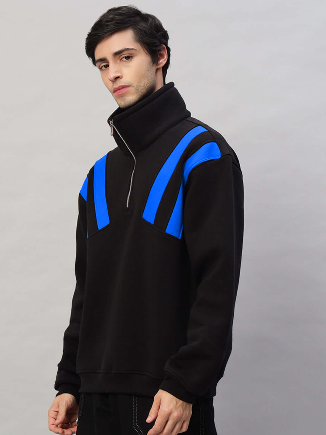 Man wearing a black and blue CROSSBAR fleece colorblock jacket with high collar and zipper.