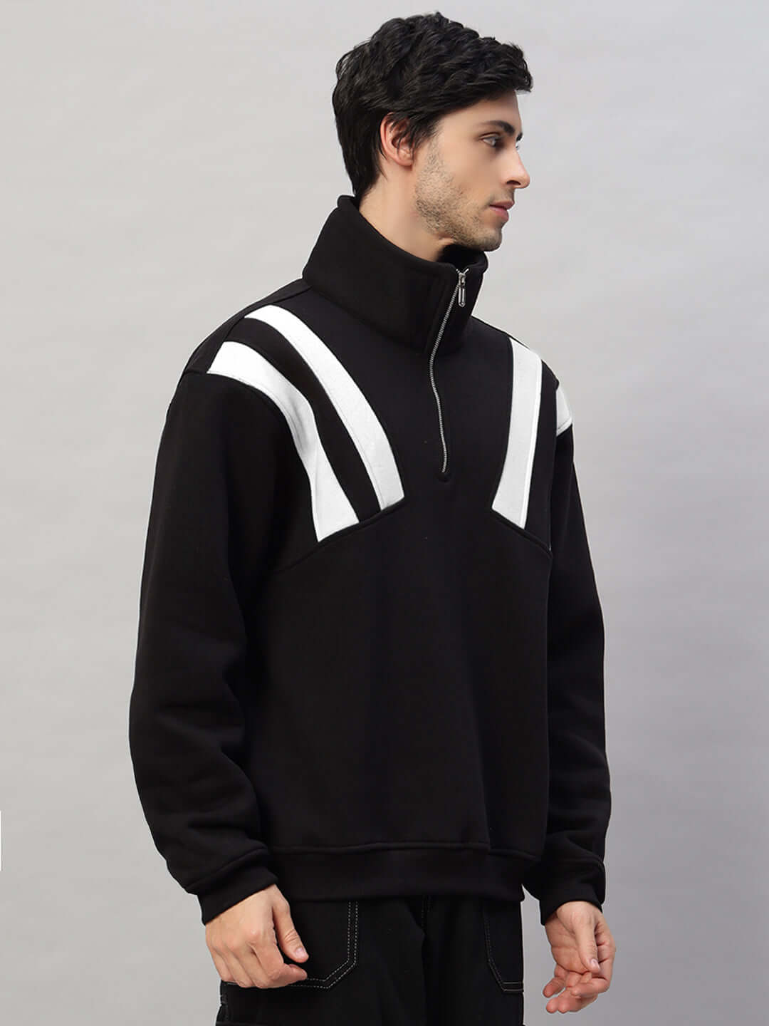 Model wearing CROSSBAR FLEECE COLORBLOCK JACKET in black and white with a zip collar, featuring stylish colorblock design.