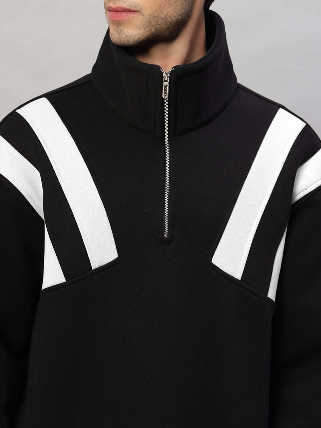 Close-up of black and white crossbar fleece colorblock jacket with zippered collar.