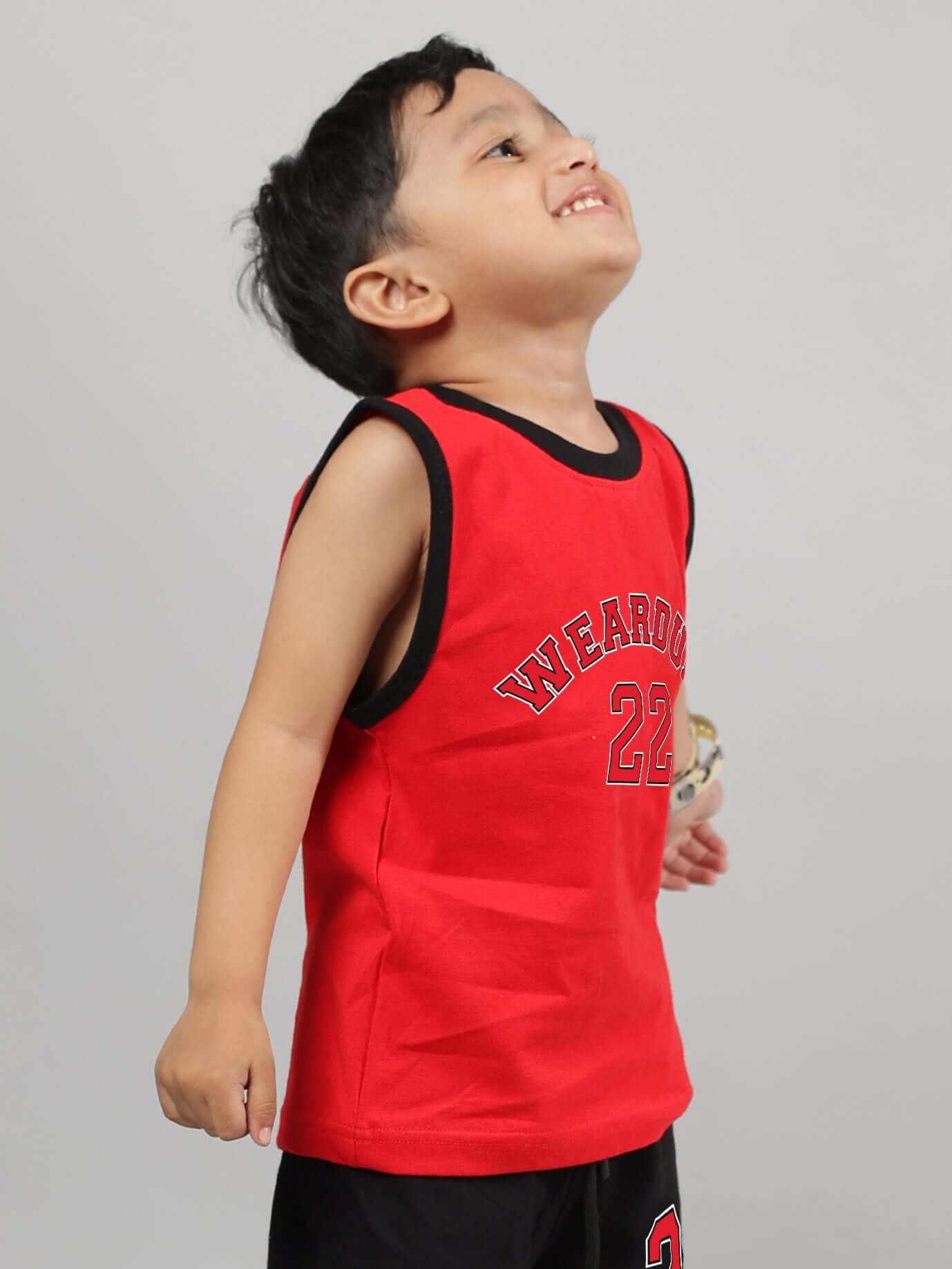 Smiling child wearing a red AMIGA t-shirt, suitable for both boys and girls, designed by DUDS. Made-to-order with custom fit option.