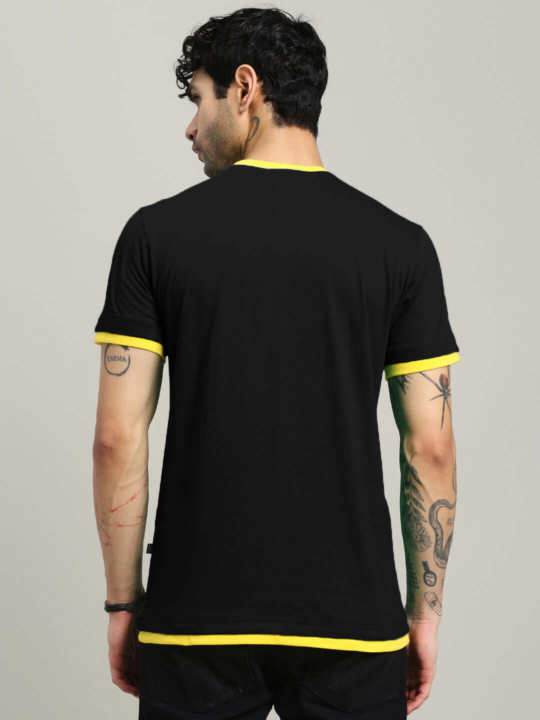 Back view of a man wearing a NIMO Regular Fit Black T-Shirt with yellow accents, made from 100% cotton. Premium design from India.