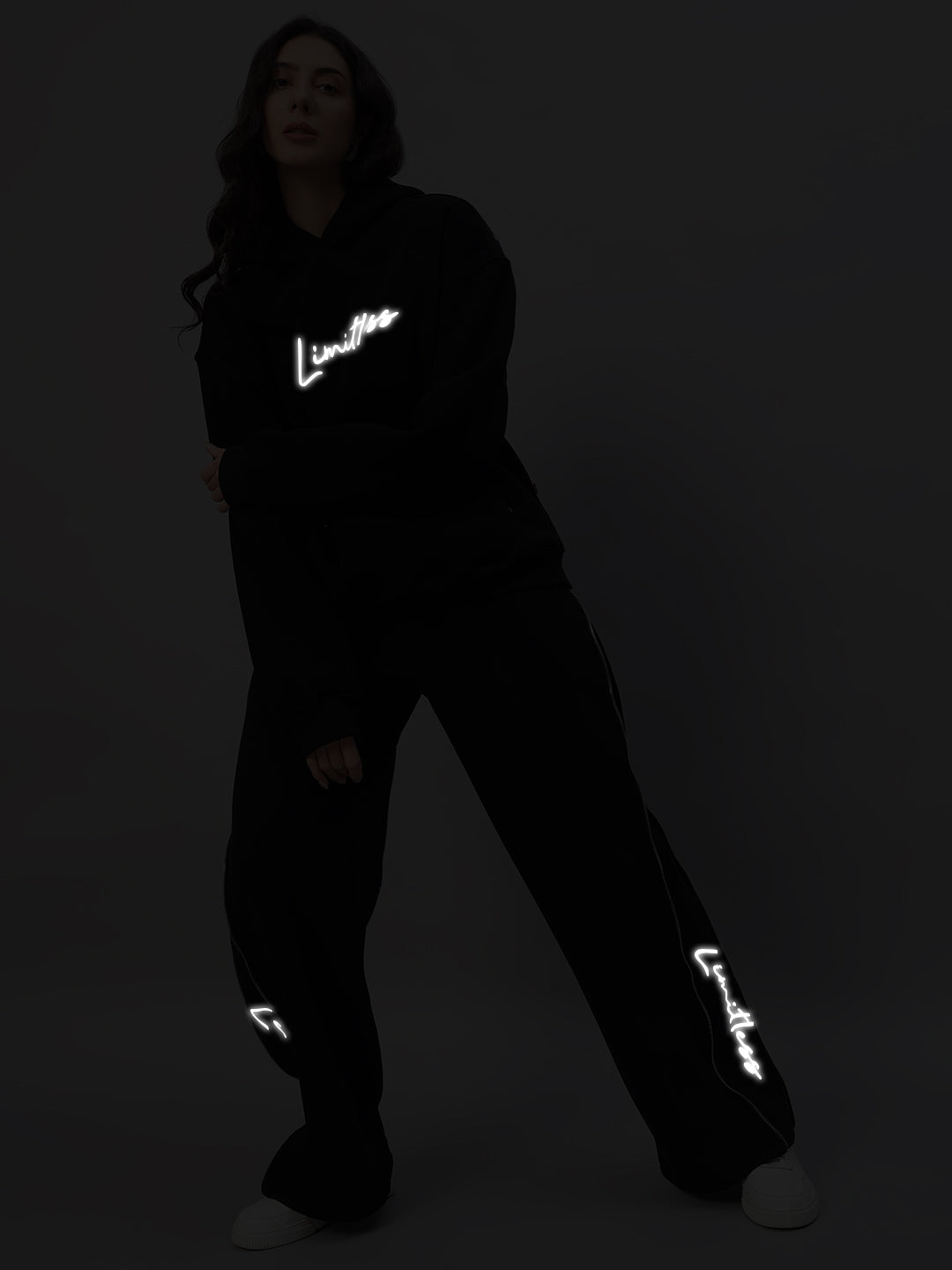 Model wearing Women's Limitless Fleece Reflector Co-ord in black with reflective logo accents.