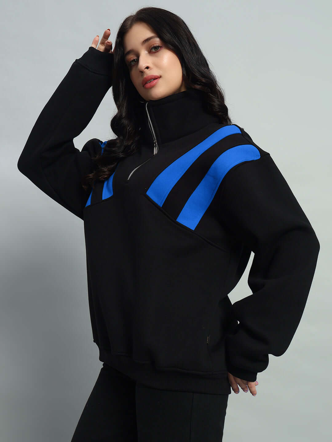 Woman wearing a black and royal blue colorblock crossbar fleece jacket.