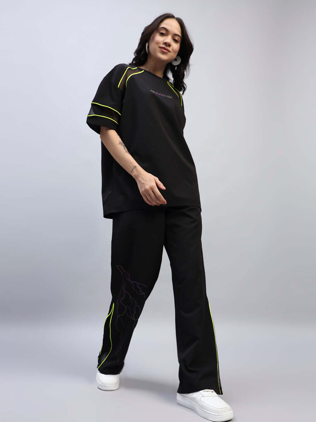 Woman wearing women's black Salvo Reflector relaxed-fit joggers with neon details, showing a casual and comfortable style.