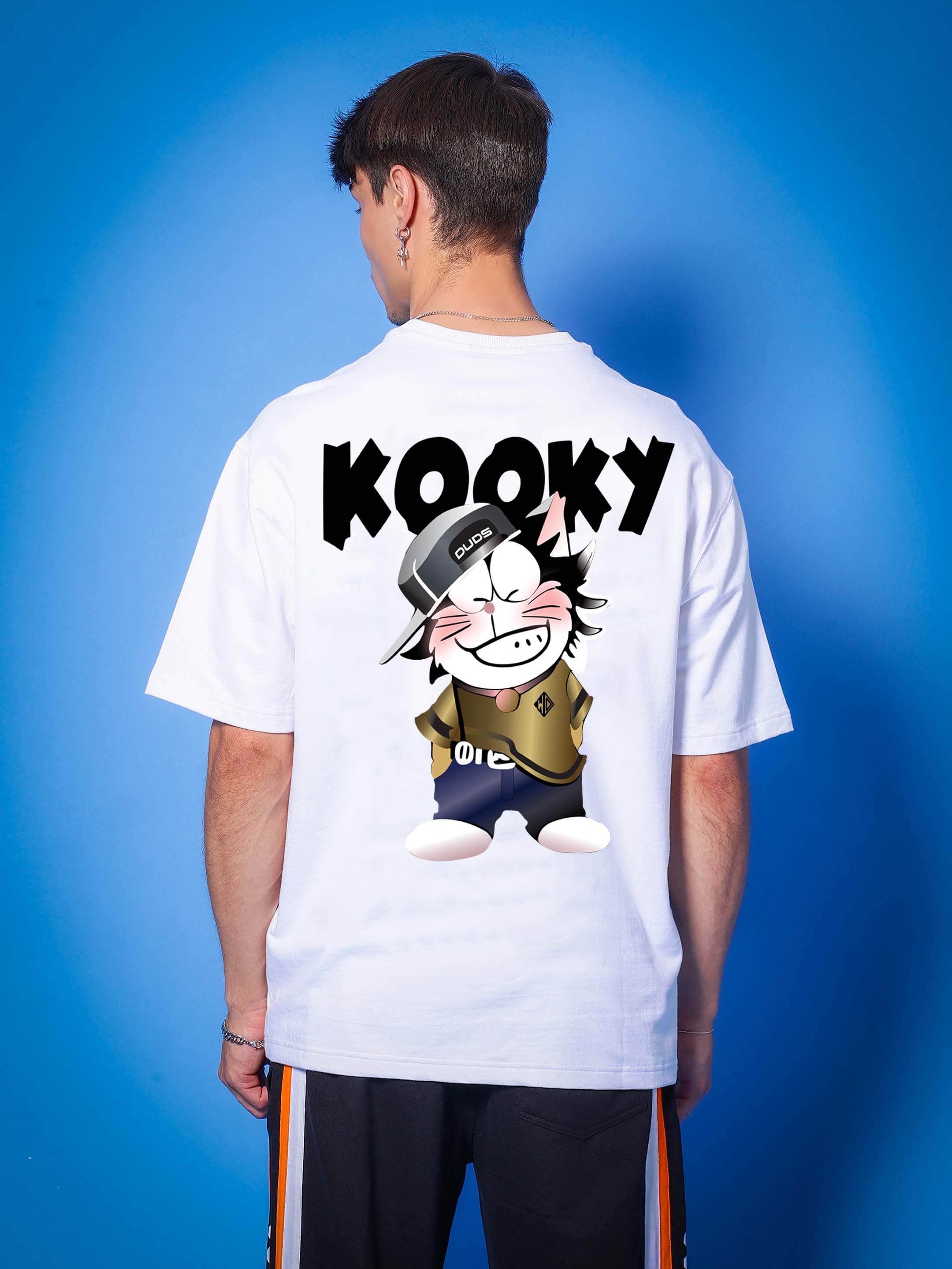 Person wearing KOOKY OVER-SIZED T-SHIRT WHITE with cartoon graphic on back, blue background.
