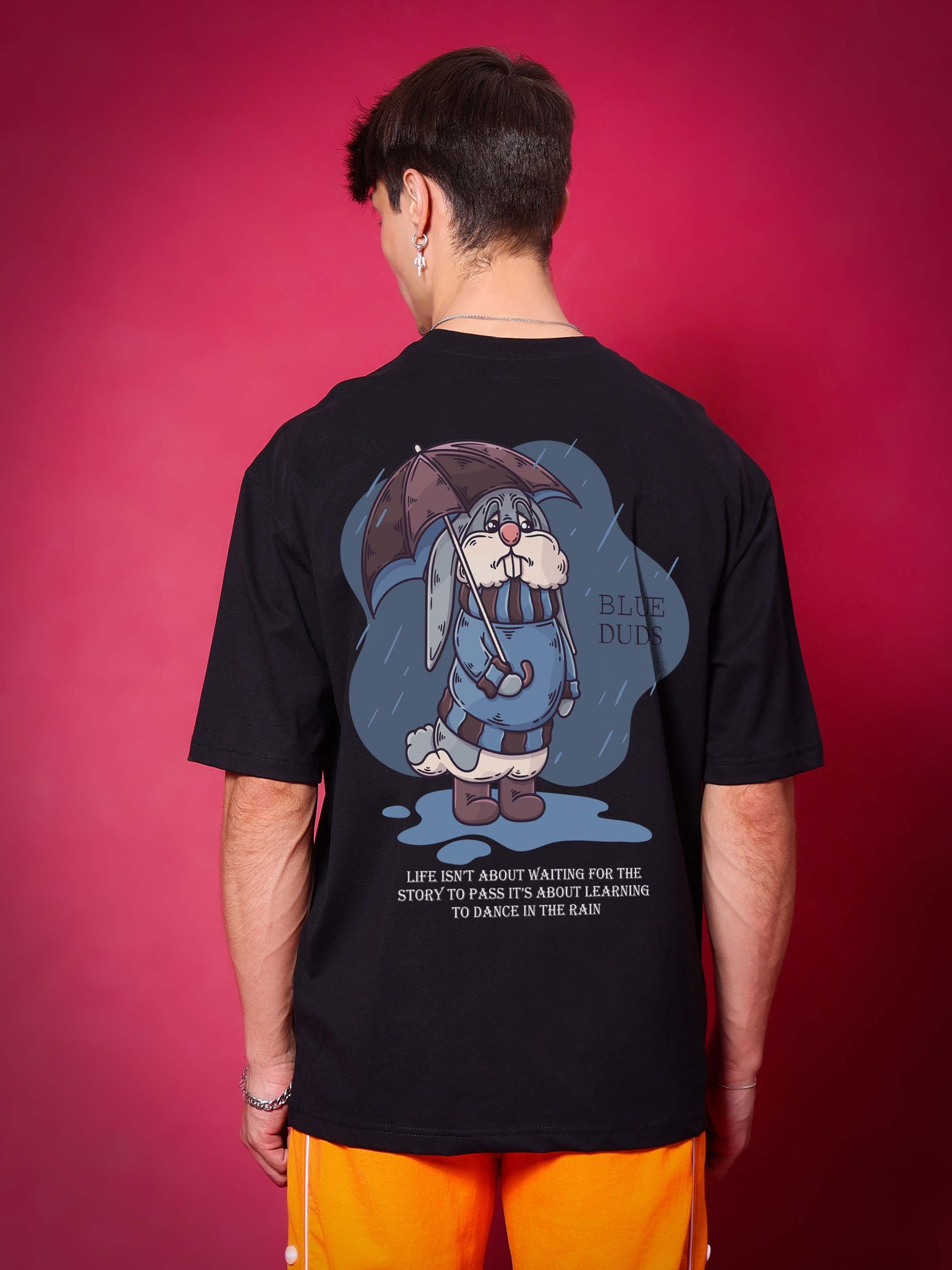 Person wearing BLUE LAPIN OVER-SIZED T-SHIRT BLACK with graphic design, made of premium heavy gauge fabric.