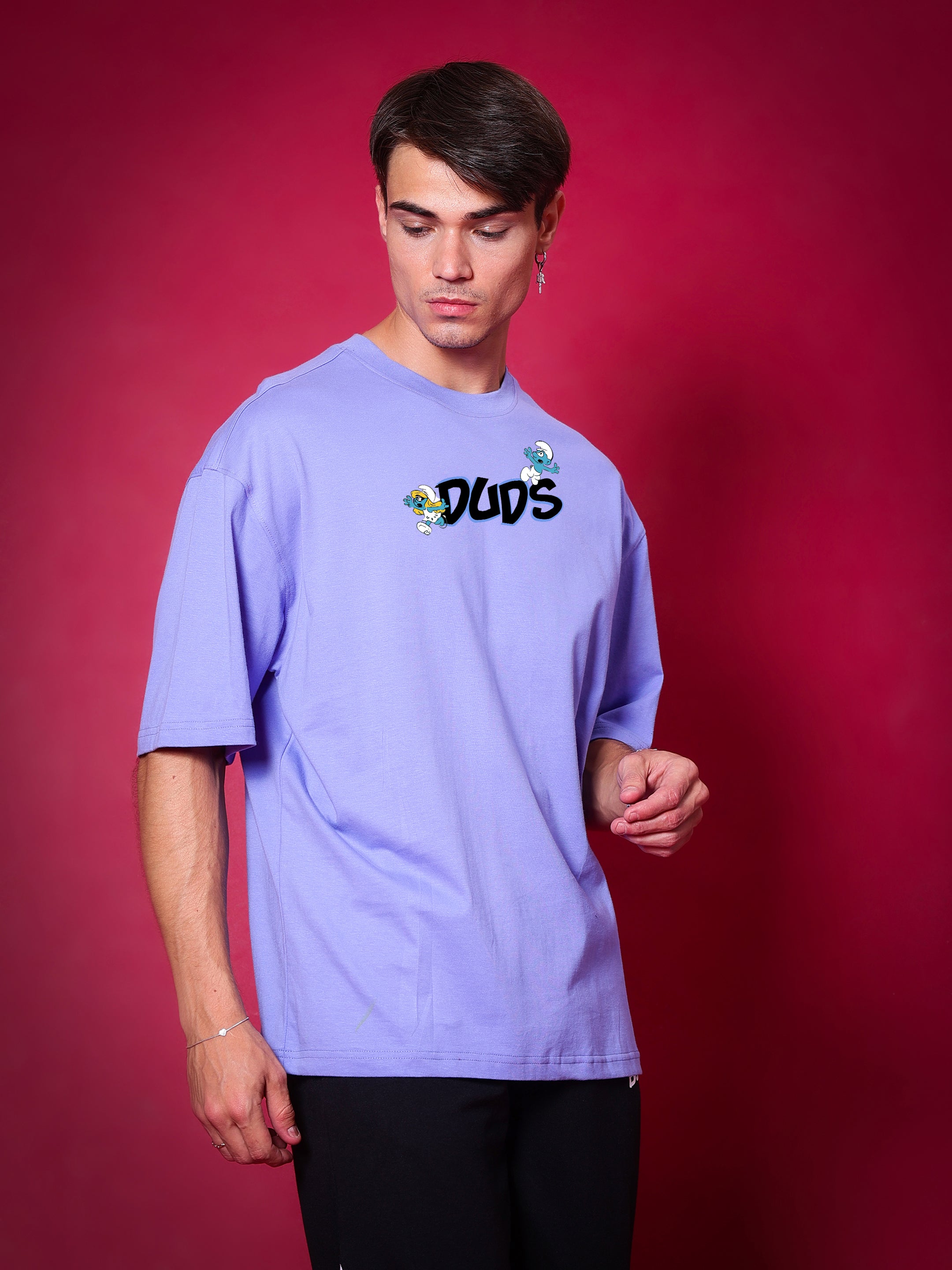 Man wearing SMURFS OVER-SIZED T-SHIRT PURPLE against red background.