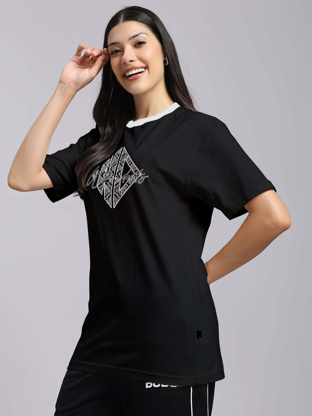 Woman wearing black women's angular regular fit t-shirt, 100% cotton with geometric print, styled casually.