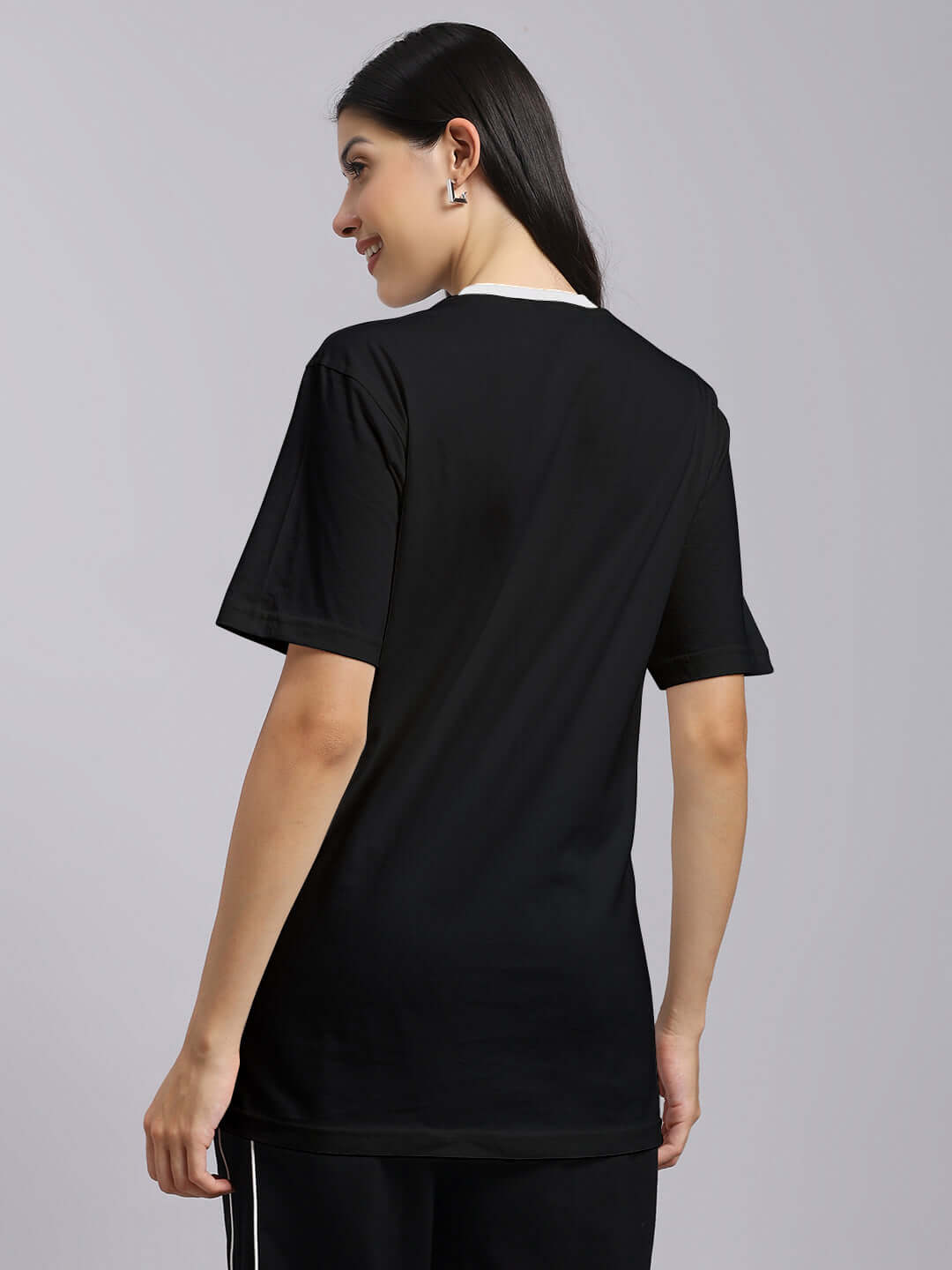Woman wearing a black regular fit t-shirt made of 100% cotton, showcasing the back design and comfortable fit.