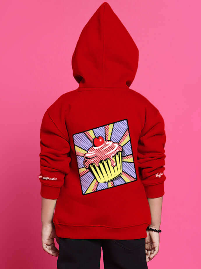 Child wearing a red cupcake oversized hoodie with graphic design, suitable for boys and girls.