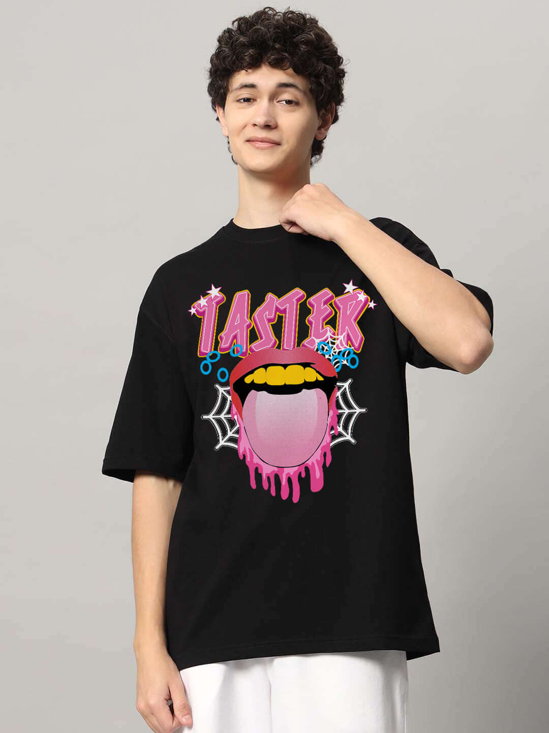 Model wearing TASTER OVER-SIZED T-SHIRT BLACK with vibrant graphic print.