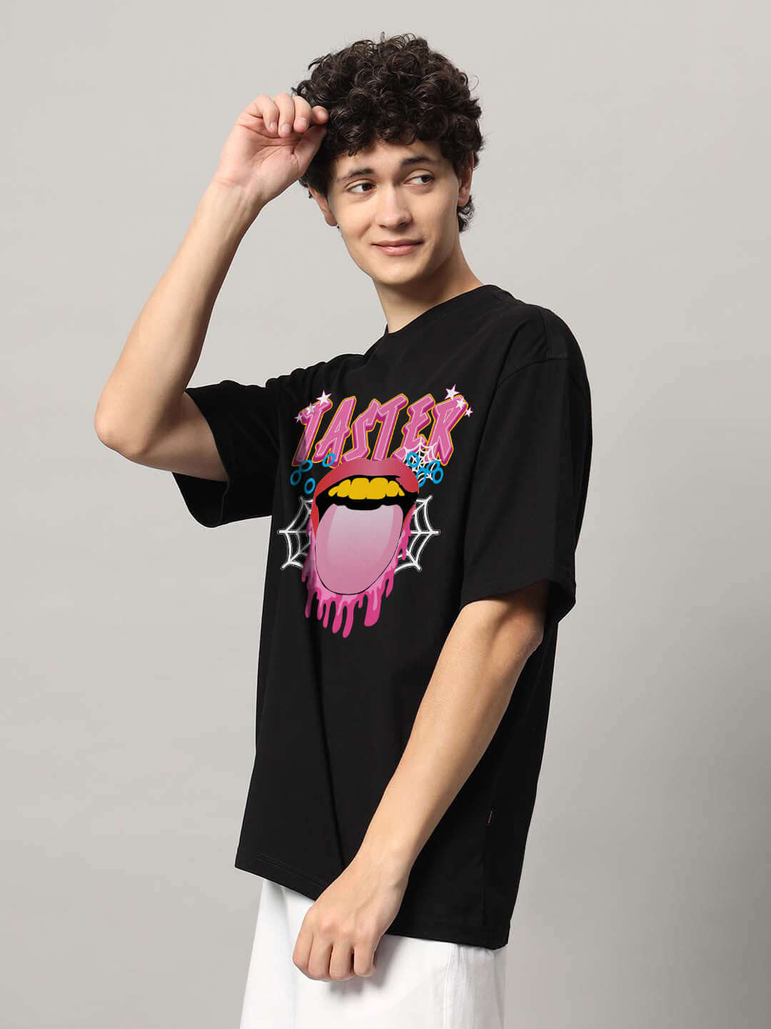 Person wearing TASTER OVER-SIZED T-SHIRT BLACK with colorful graphic design; ideal for casual, customizable fit option available for prepaid orders.