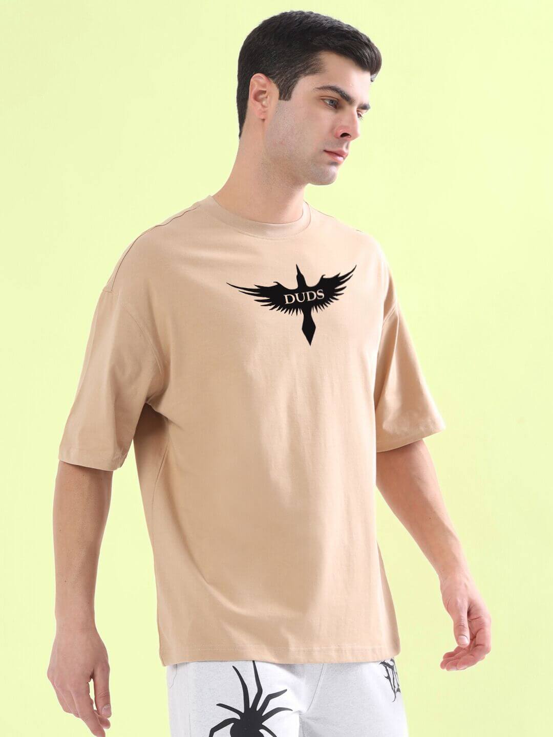 SILENT BUT POWERFUL PRINTED T-SHIRT BEIGE worn by a man against a light green background.