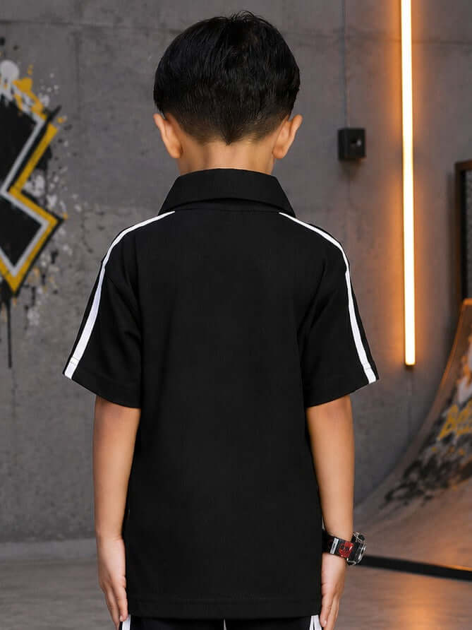 Boy wearing CHAMPION TRACK POLO T-SHIRT FOR BOYS GIRLS BLACK, showcasing the back design with white stripes.