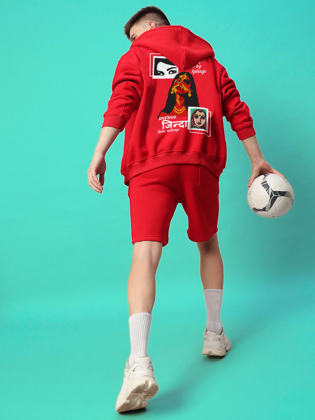 Person wearing A LOOK ATTITUDE FLEECE HOODIE RED with graphic design, holding a soccer ball.