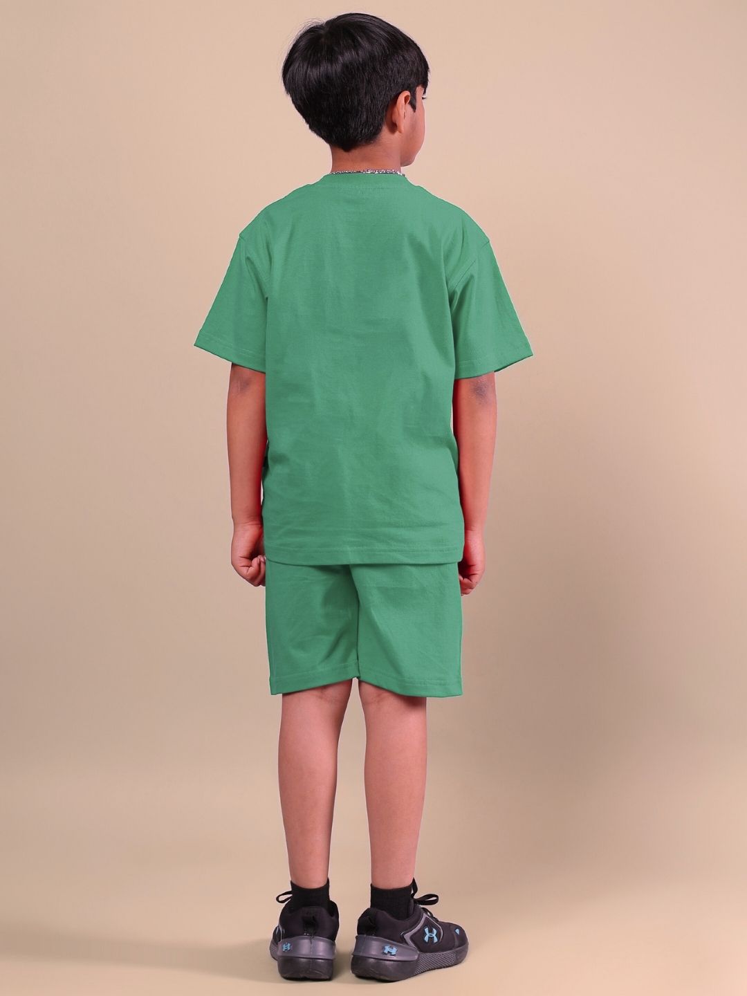 Child wearing ACE co-ord set in vibrant green, featuring a short-sleeve top and matching shorts, showcasing unisex fashion for boys and girls.
