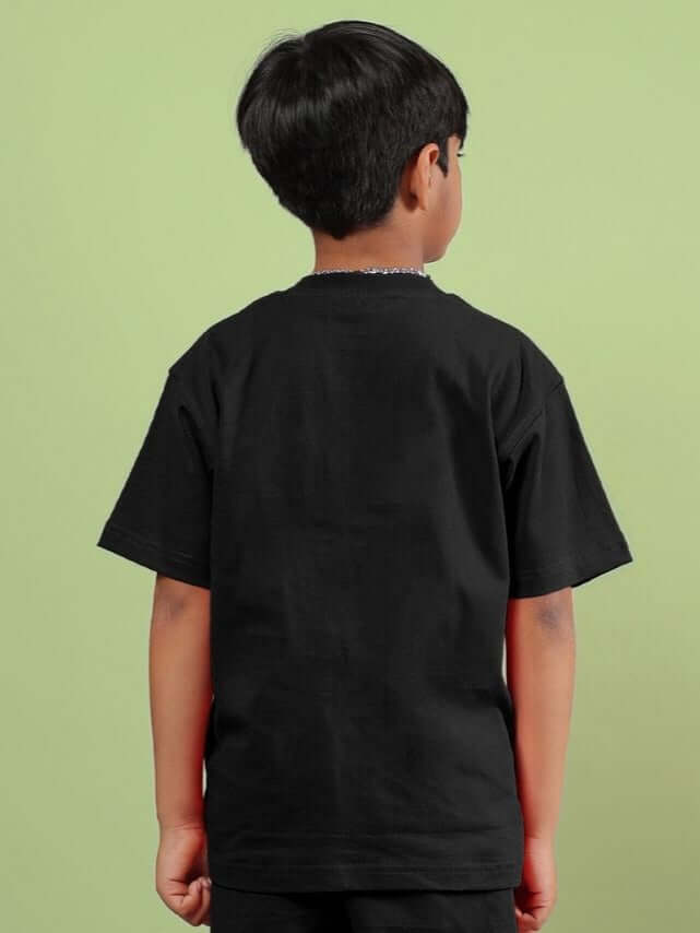 Back view of child wearing ACE T-SHIRT FOR BOYS AND GIRLS BLACK, showcasing the sleek and versatile design in a casual setting.