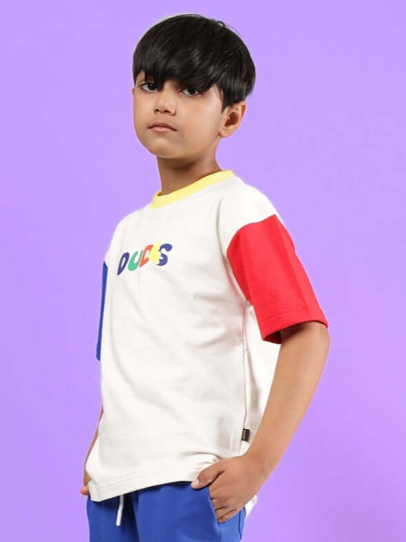 Young boy wearing Adonis oversized off-white T-shirt with colorful sleeves, made to order by DUDS.