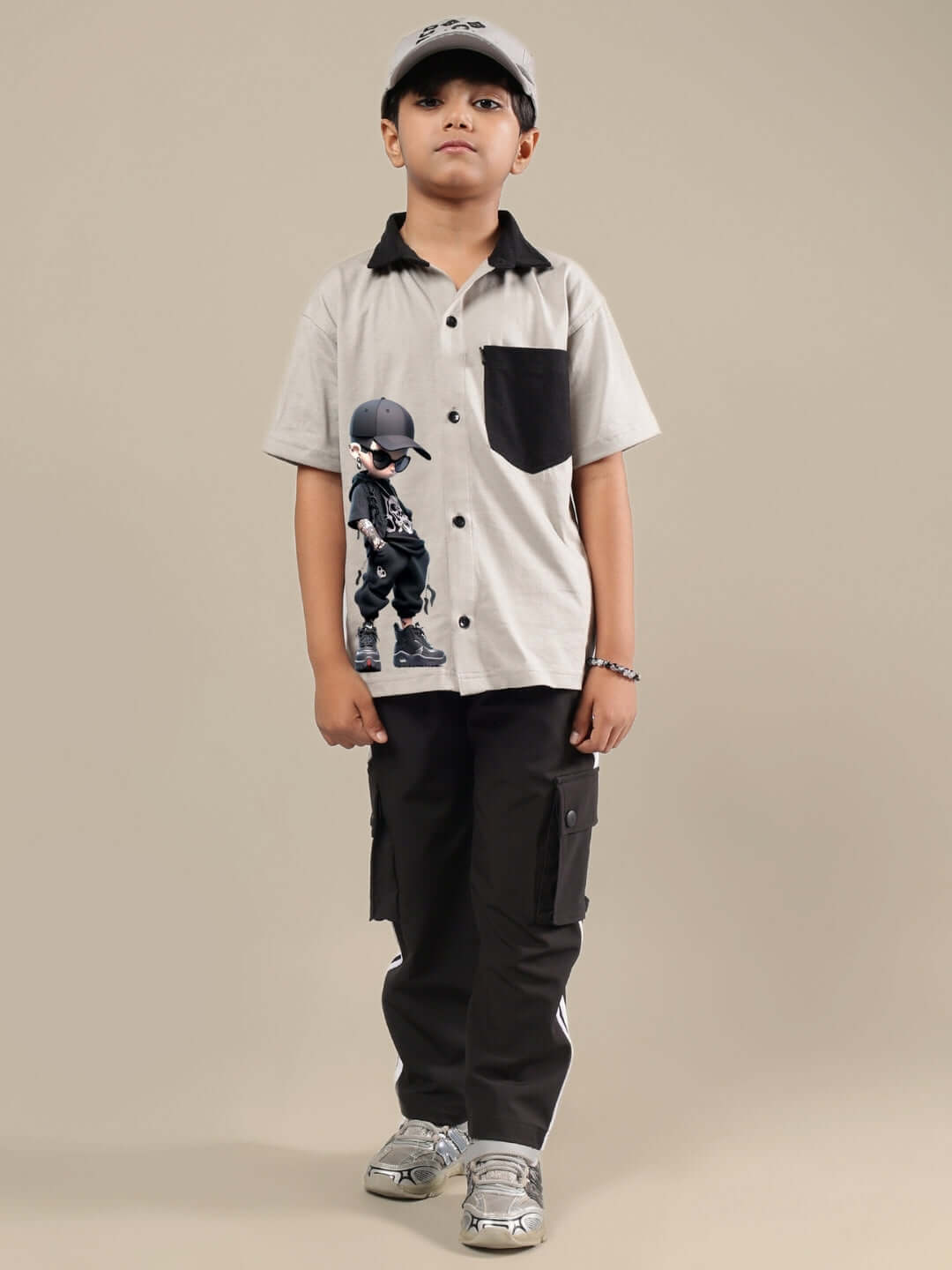 Young boy wearing the DUDS grey-black co-ord set, featuring button-up shirt with pocket and matching cargo pants.