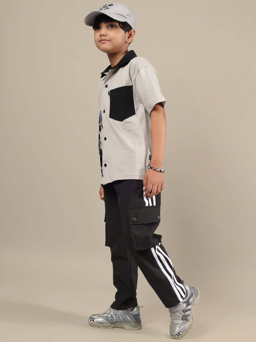 Boy wearing grey-black co-ord set by DUDS, featuring cargo pants and a collared shirt, perfect for customizable, made-to-order fits.