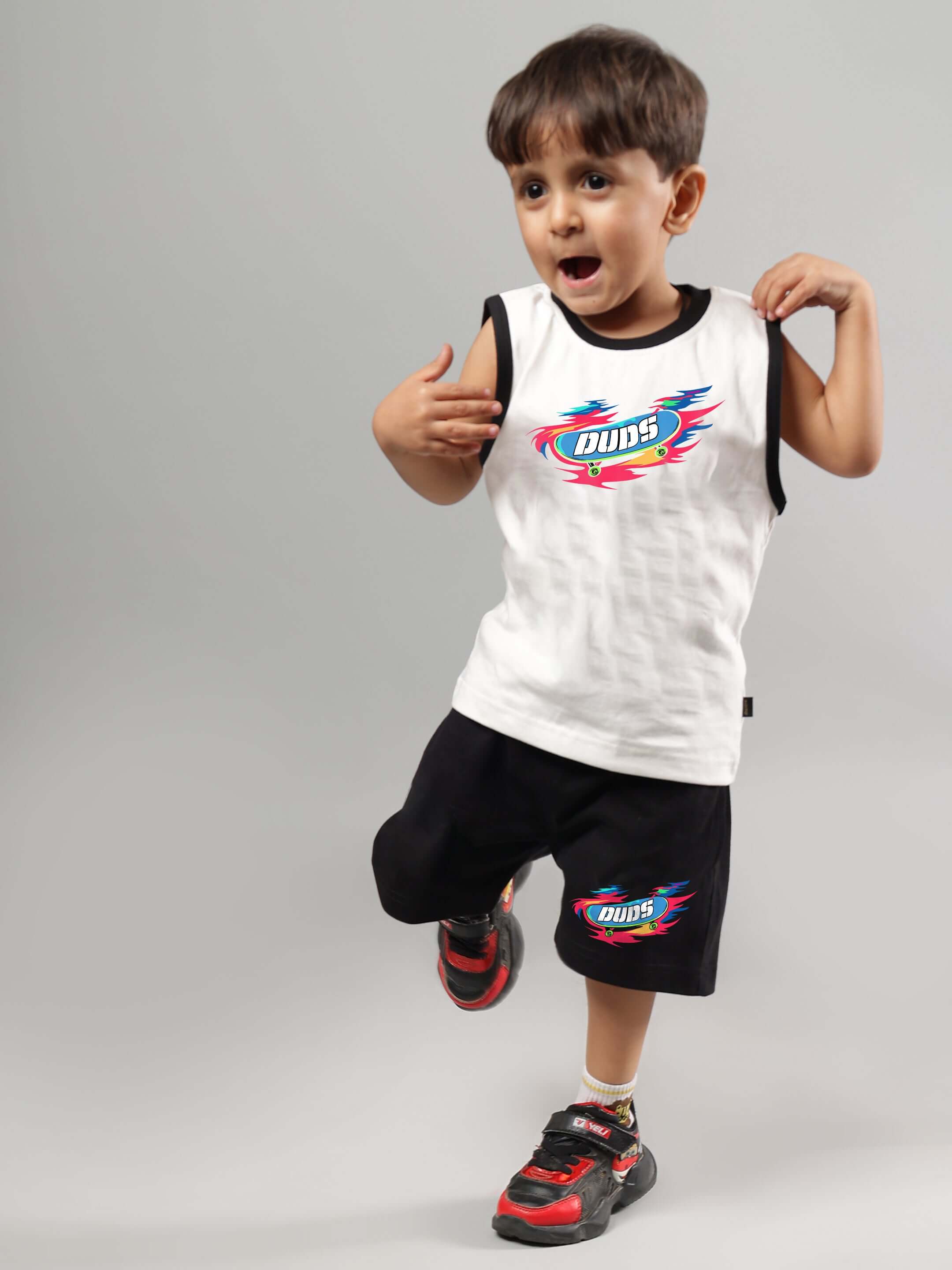 Boy wearing Alien Summer Co-Ord for Boys Girls Off White-Black set with colorful graphic, posing in studio; trendy unisex kids outfit.