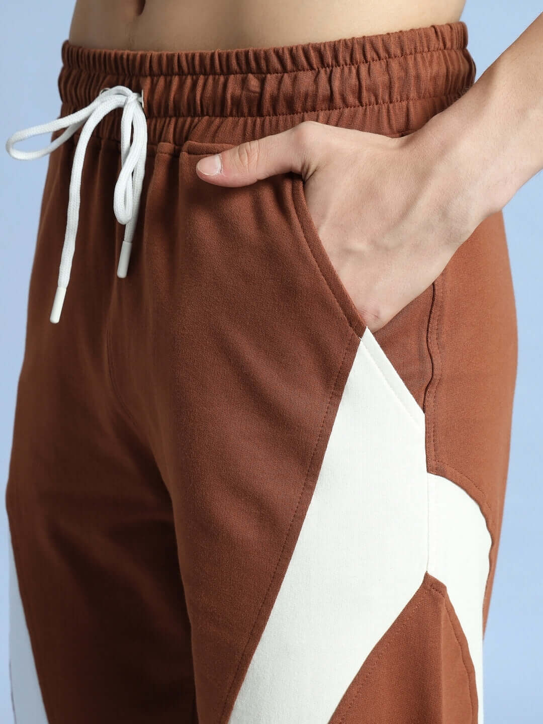 Close-up of brown-white American football joggers with side pocket, showcasing tailored fit and detailed stitching.