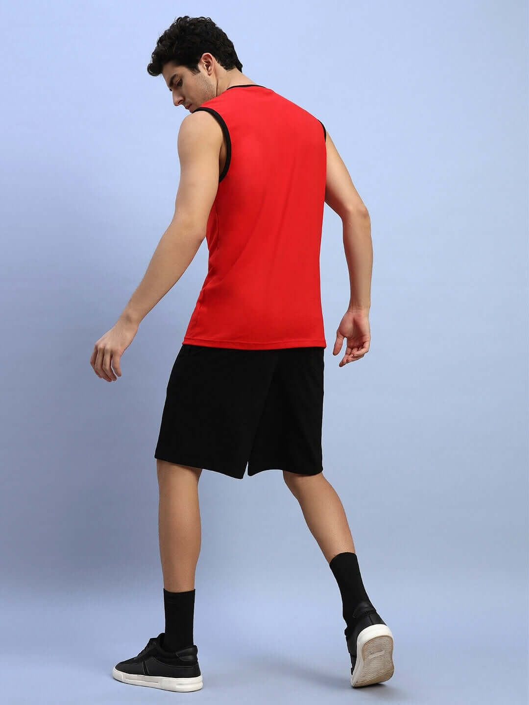 Back view of a person wearing AMIGA GYM CO-ORD SET RED-BLACK, highlighting sleeveless red top and black shorts designed for workouts.