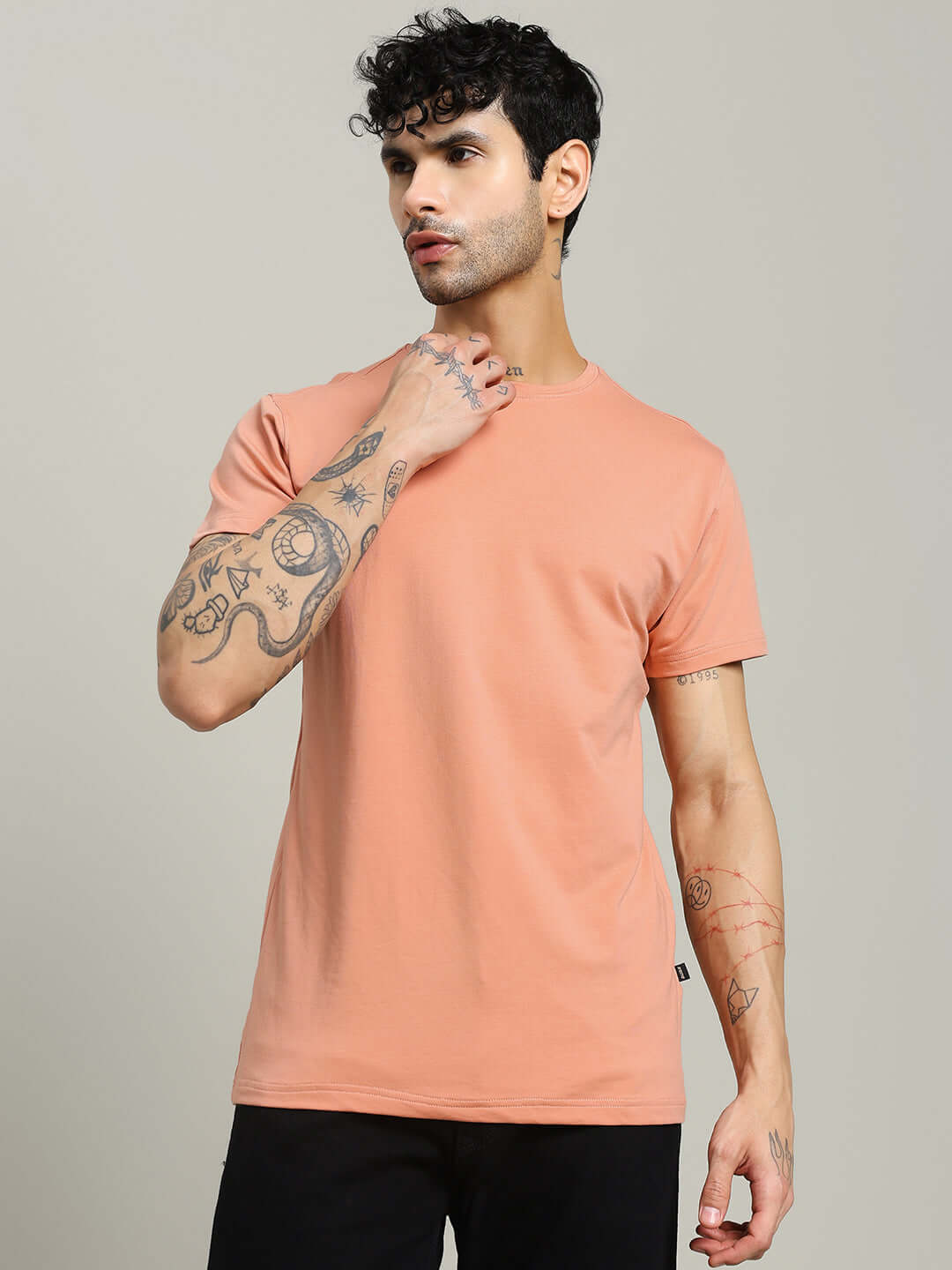 Model wearing Andrew Regular Fit T-Shirt in peach, made from premium bio-washed 100% cotton fabric, ideal for casual wear.