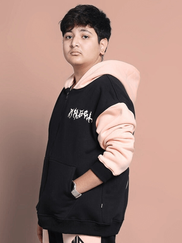 Boy wearing ANGEL WINGS oversized black-beige hoodie, side view. Stylish casual fashion for boys and girls.