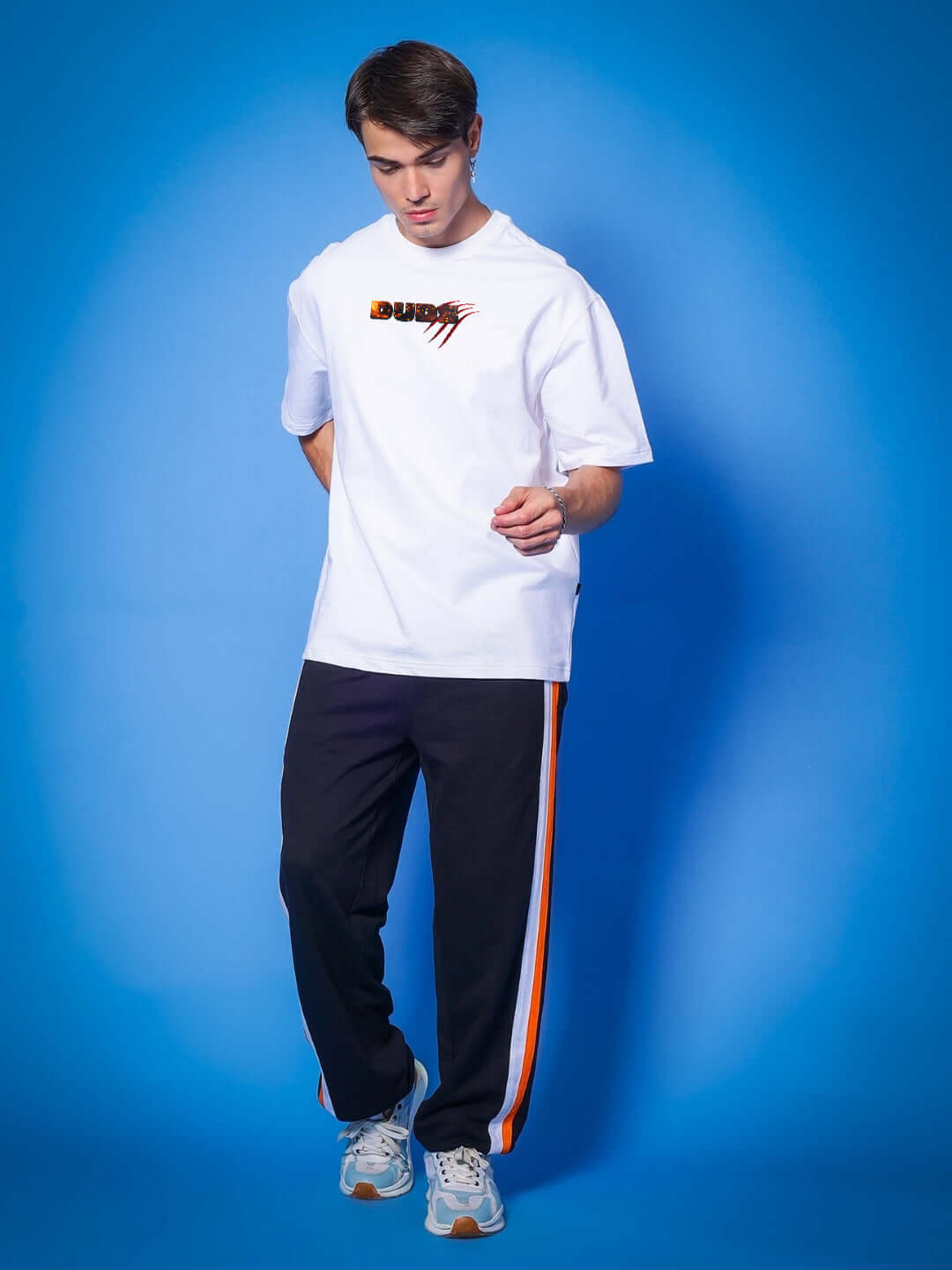 Model wearing ANGRY PANTHER OVERSIZED T-SHIRT WHITE with black pants against a blue background.