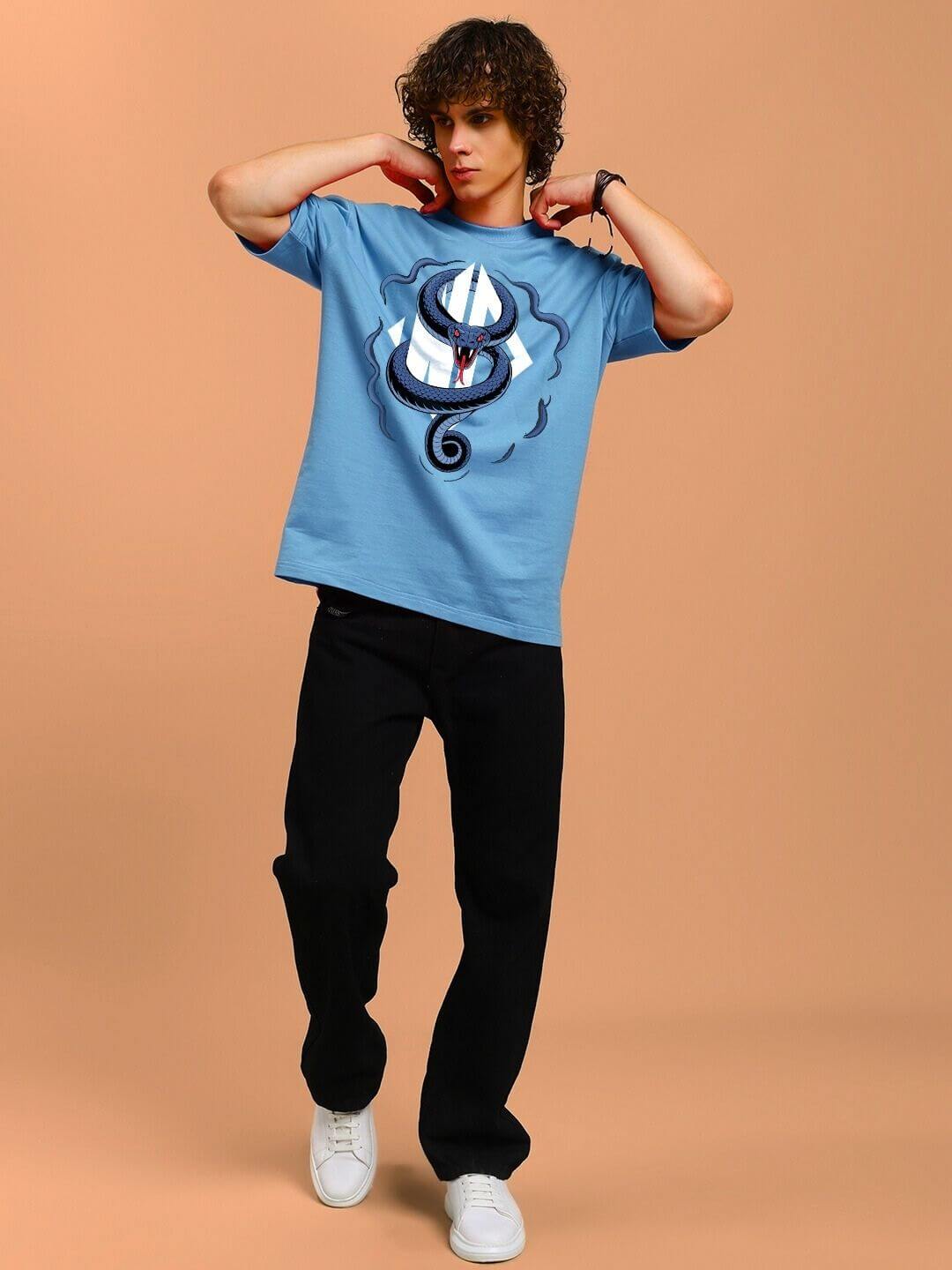Model wearing ANGRY SNAKE WD PRINTED OVERSIZED T-SHIRT LIGHT BLUE, featuring a snake graphic and WD print, casual streetwear style.