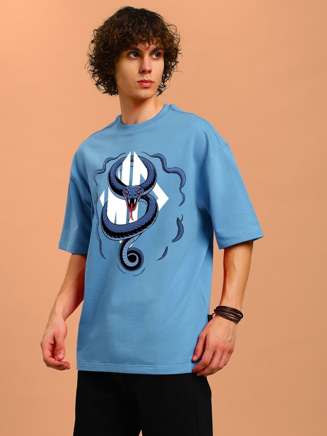 Model wearing ANGRY SNAKE WD PRINTED OVERSIZED T-SHIRT LIGHT BLUE with bold snake design on front.
