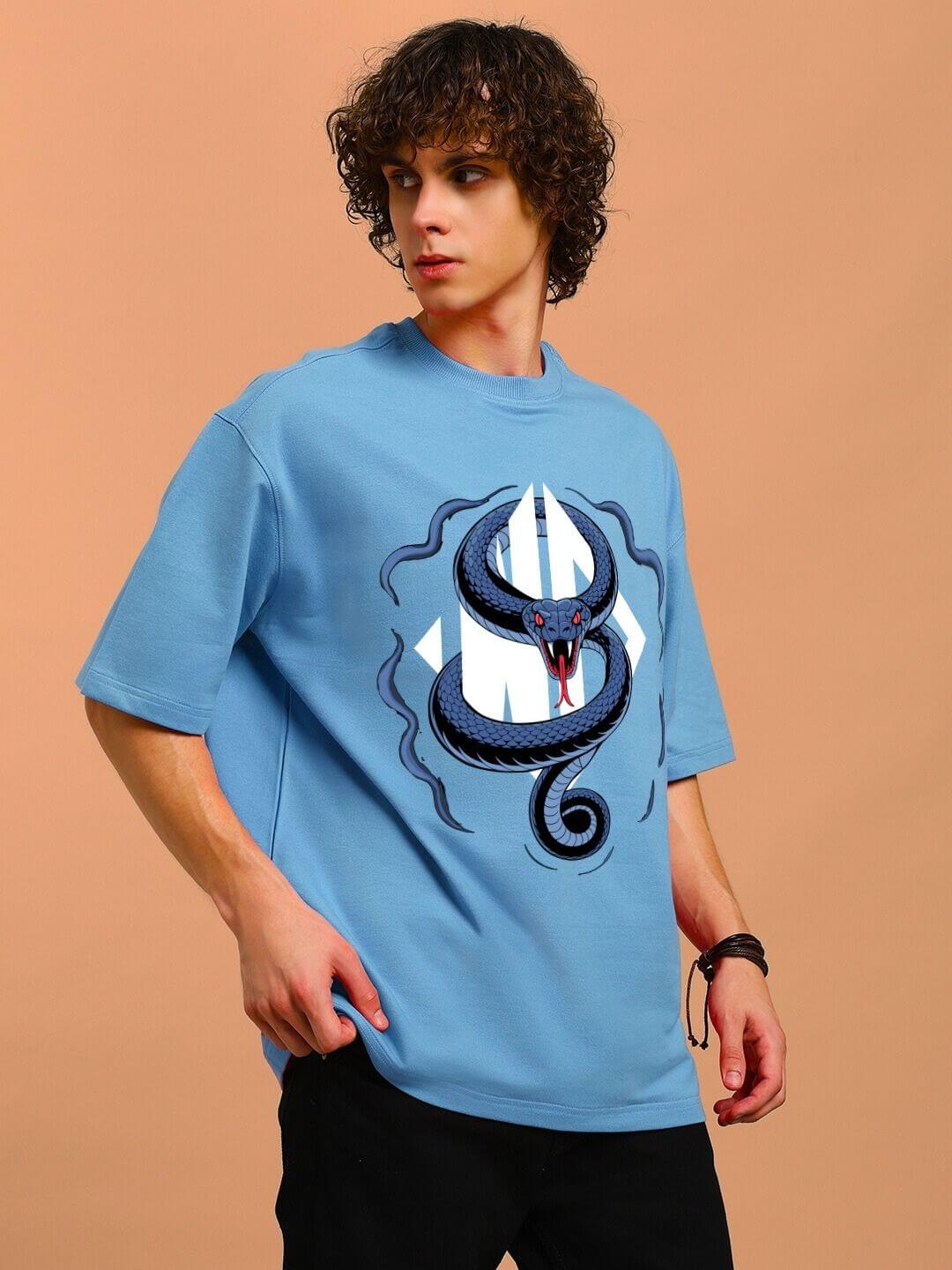 Model wearing ANGRY SNAKE WD PRINTED OVERSIZED T-SHIRT LIGHT BLUE with snake graphic on soft fabric