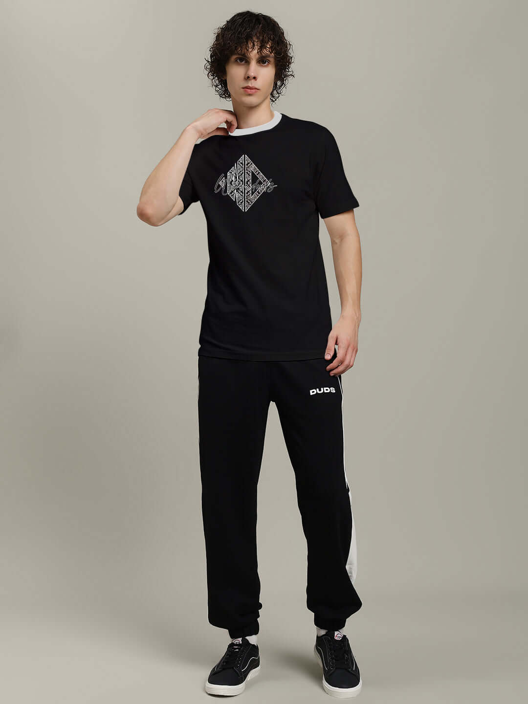 Model wearing Angular Regular Fit T-Shirt Black with unique graphic, styled casually. Perfect for relaxed outings.
