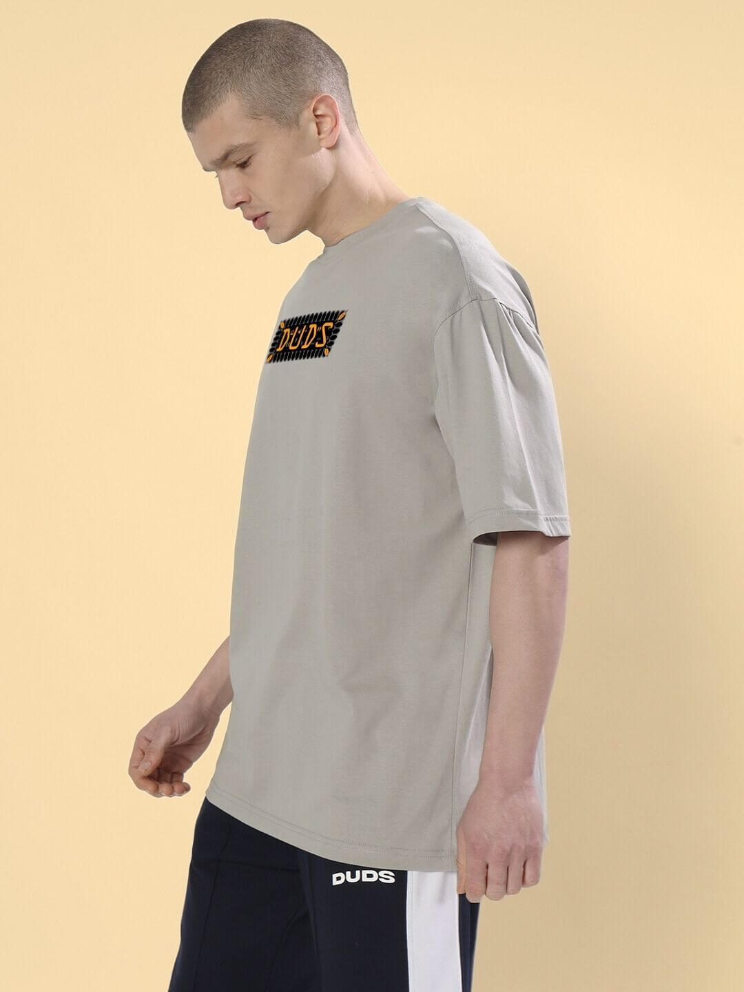 Man wearing ANUBIS EGYPTIAN PRINTED OVERSIZED T-SHIRT GREY with Anubis artwork, showcasing a cultural fashion statement.