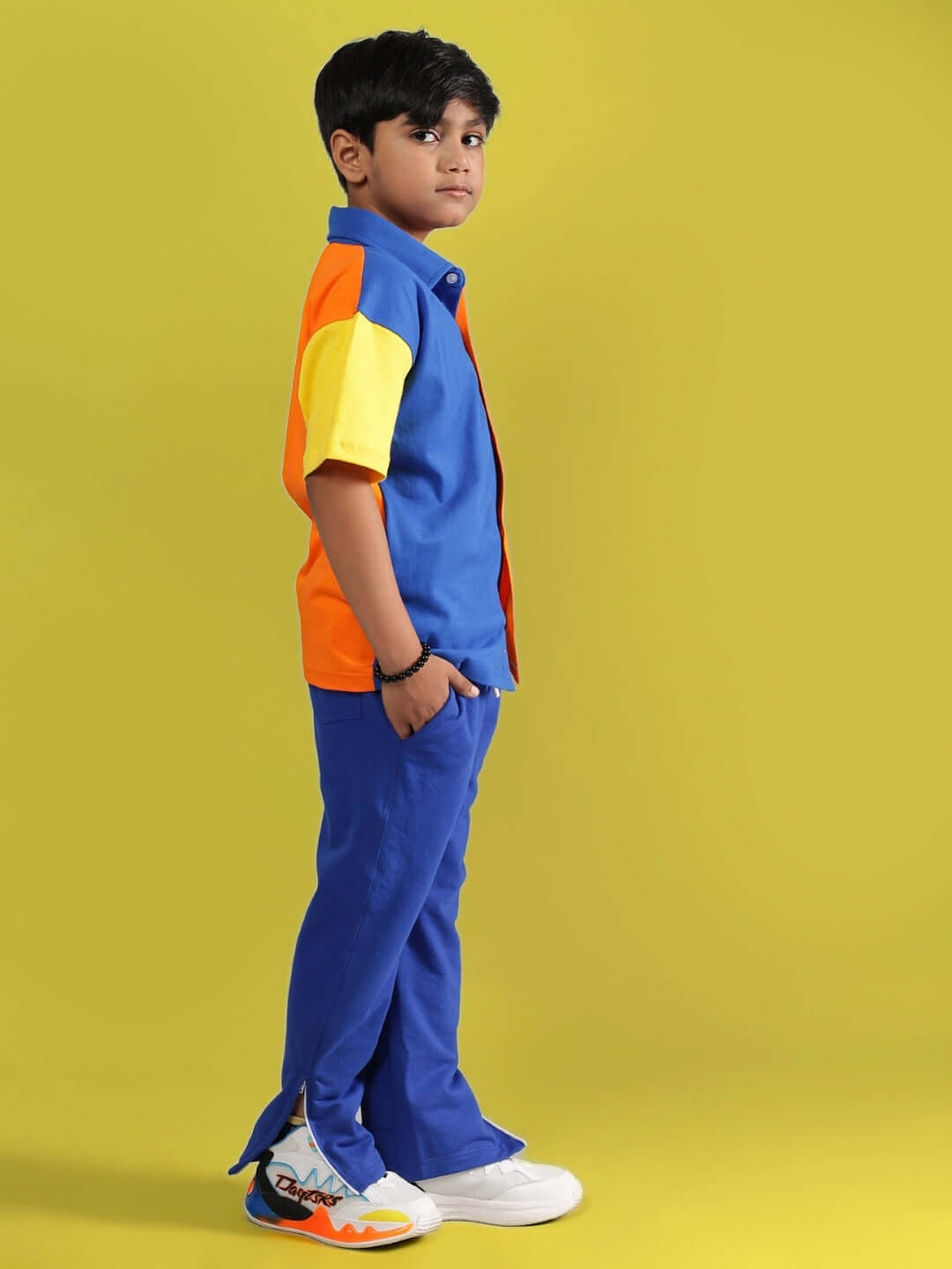 Child wearing APEX CO-ORD FOR BOYS & GIRLS MULTI-R BLUE set, featuring vibrant colors with a stylish street look on yellow background.