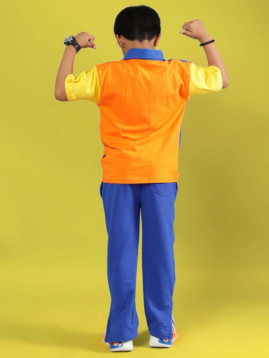 Child wearing APEX CO-ORD FOR BOYS & GIRLS MULTI-R BLUE showing the back view with bright colors on yellow background.