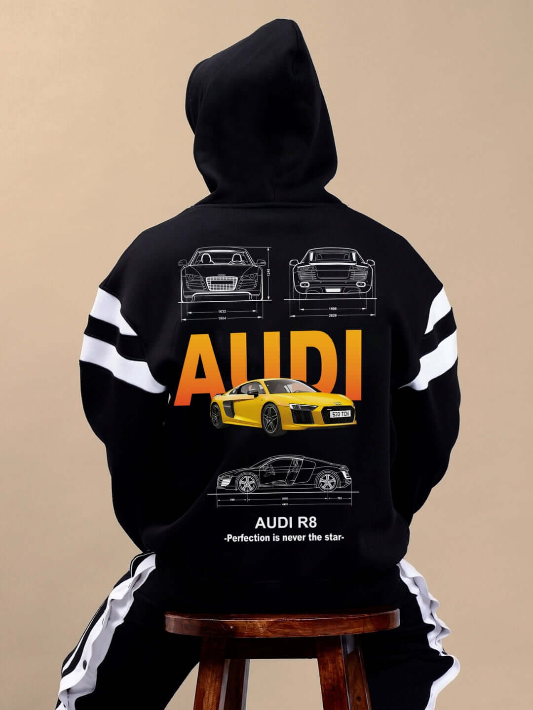 Person wearing AUDI R8 FLEECE COLORBLOCK OVERSIZE HOODIE BLACK with car graphics on back.
