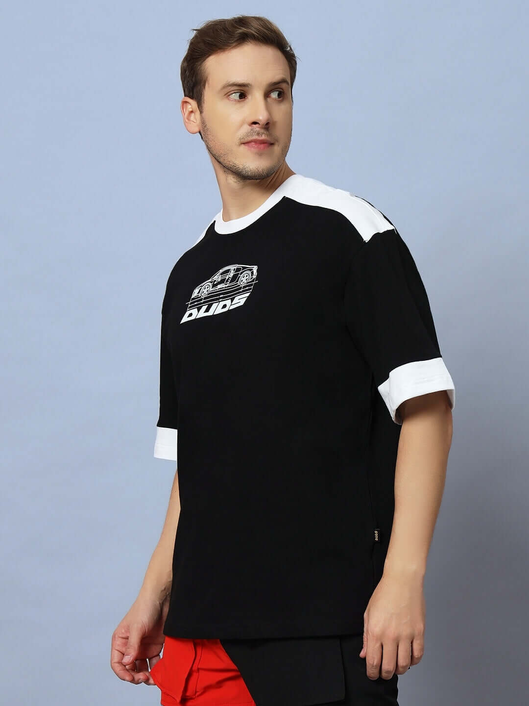 Man wearing AUDI R8 OVERSIZED T-SHIRT BLACK with Audi R8 graphic, showcasing an automotive streetwear style.