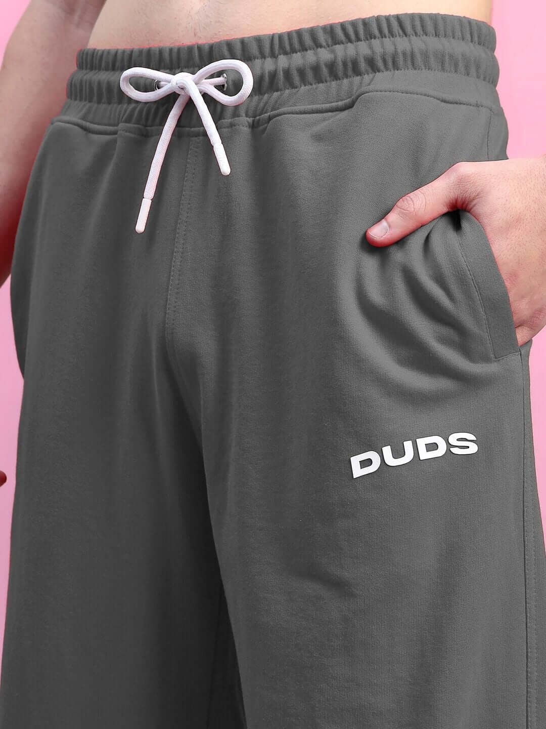 AUSTRIAN RELAXED-FIT JOGGERS GREY featuring a close-up of waistband and hand in pocket against a pink background