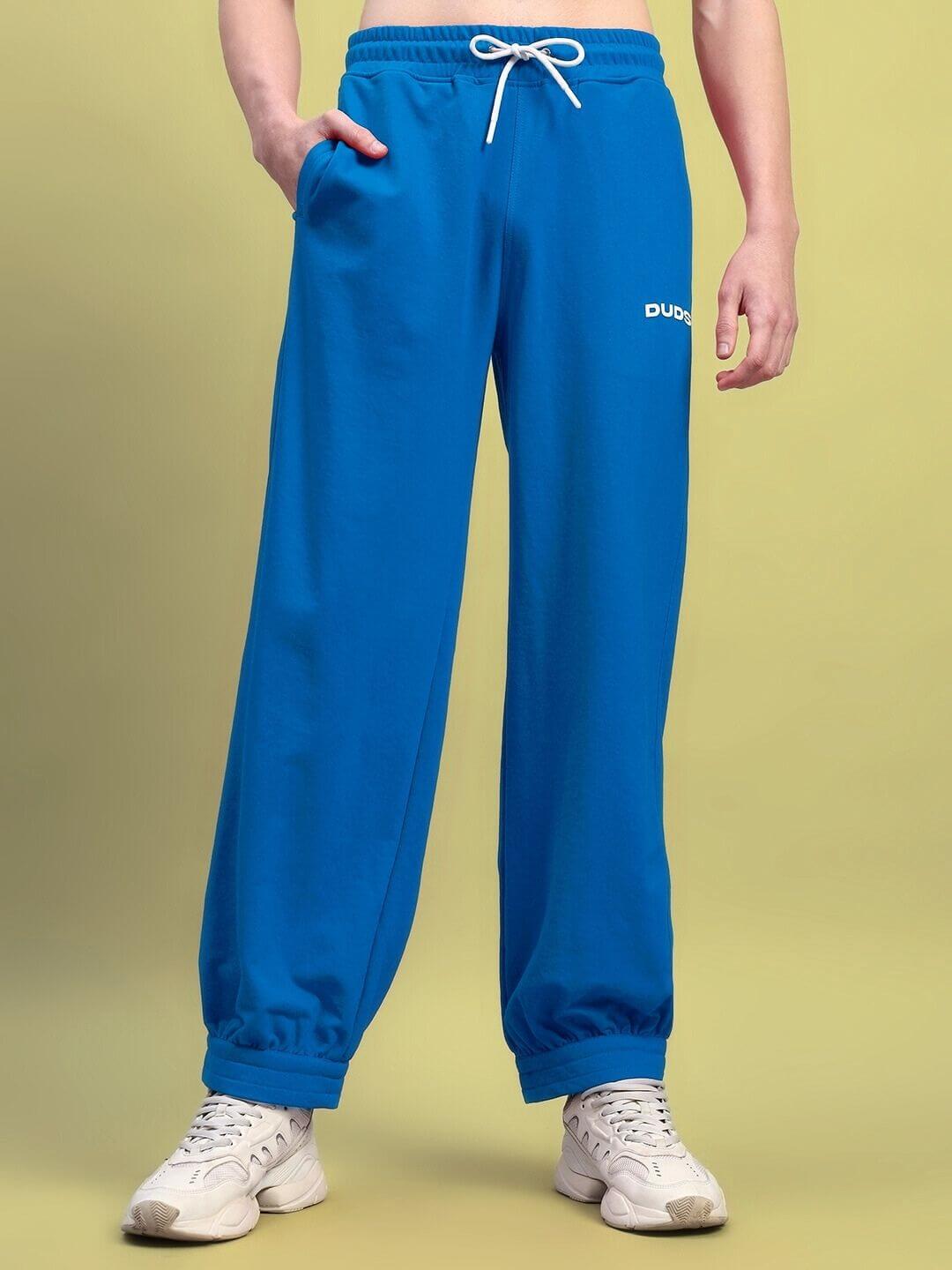 Person wearing AUSTRIAN RELAXED-FIT JOGGERS BLUE with white shoes, highlighting comfort and style.