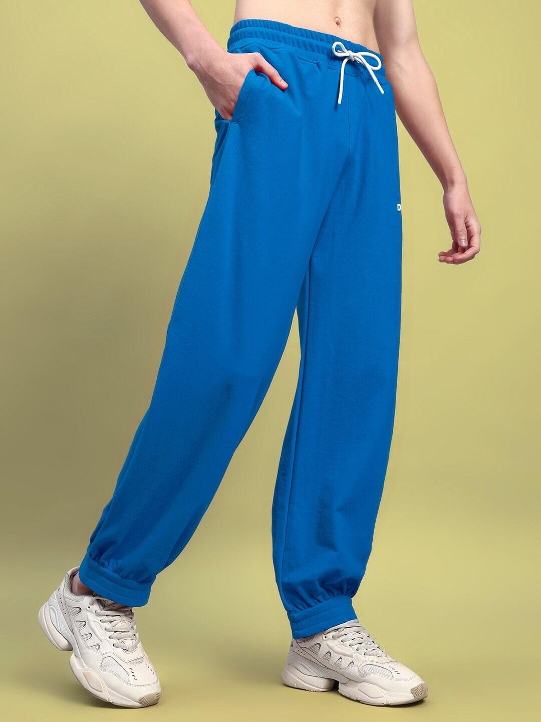 Person wearing AUSTRIAN RELAXED-FIT JOGGERS BLUE with sneakers against a plain background.