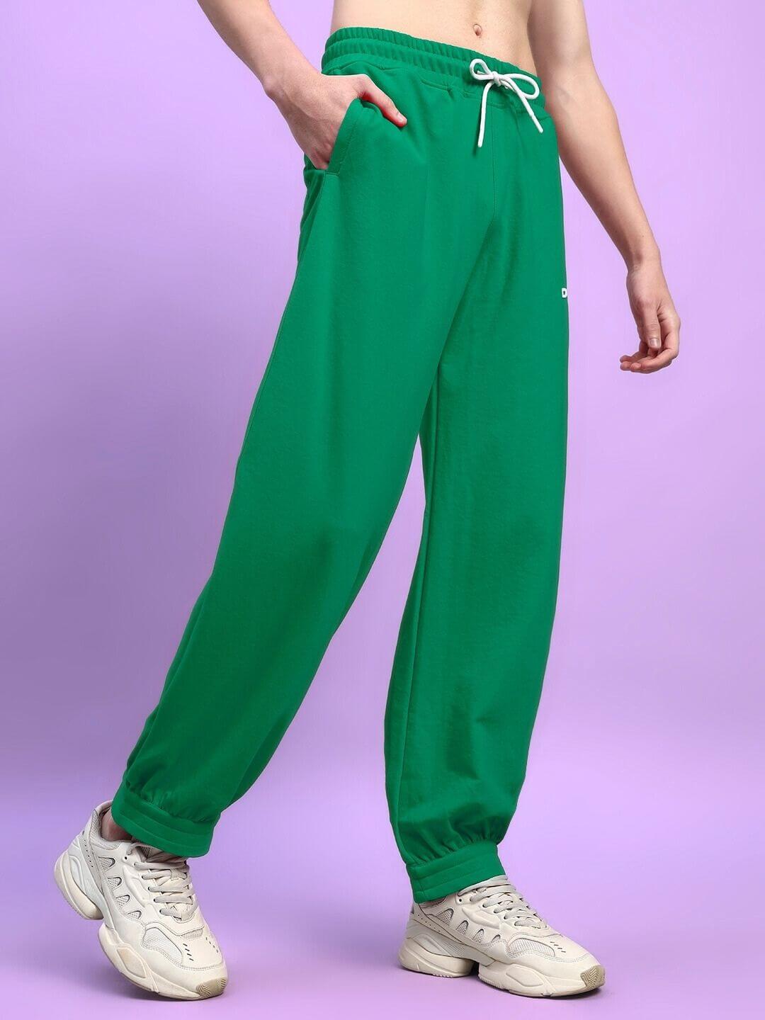 Model wearing AUSTRIAN RELAXED-FIT JOGGERS GREEN against purple background.