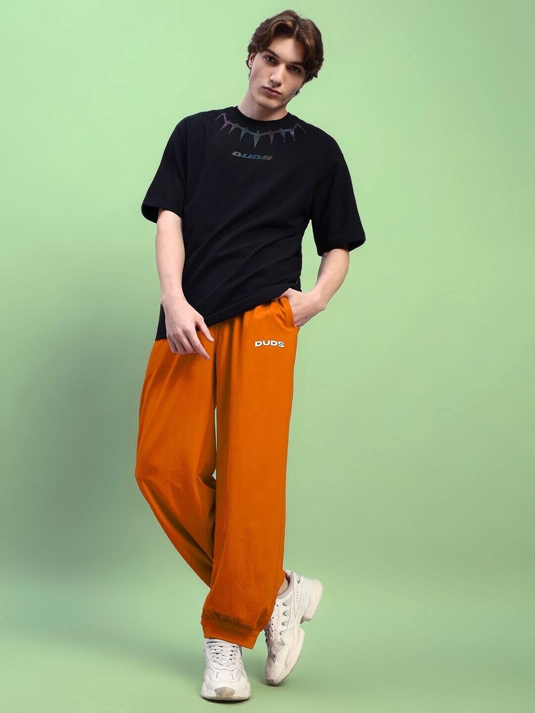 AUSTRIAN RELAXED-FIT JOGGERS ORANGE showcased with casual black t-shirt and white sneakers on a model.