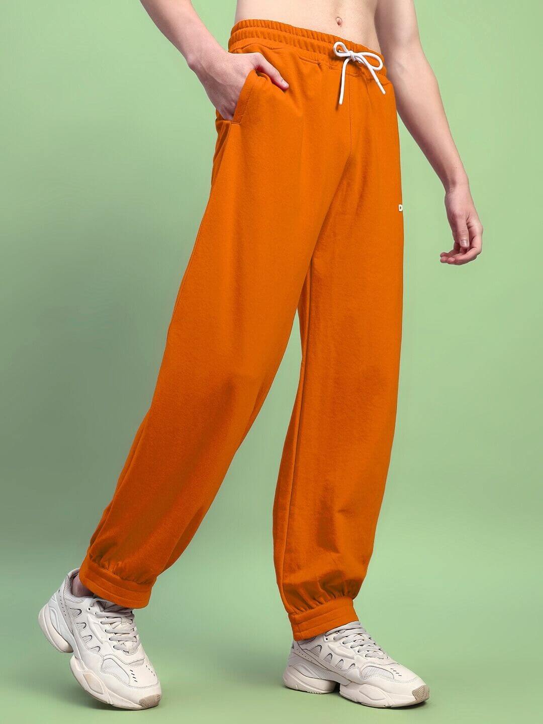 AUSTRIAN RELAXED-FIT JOGGERS ORANGE on model, vibrant orange joggers with elastic waistband, showcasing athleisure style and comfort.