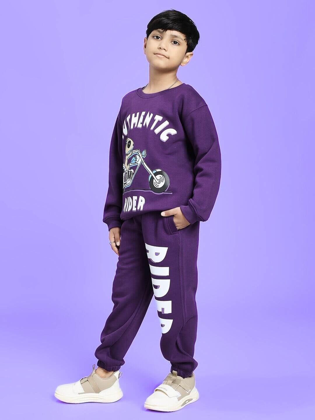 Young model wearing AUTHENTIC RIDER FLEECE CO-ORD FOR BOYS AND GIRLS PURPLE, standing confidently against a purple background.
