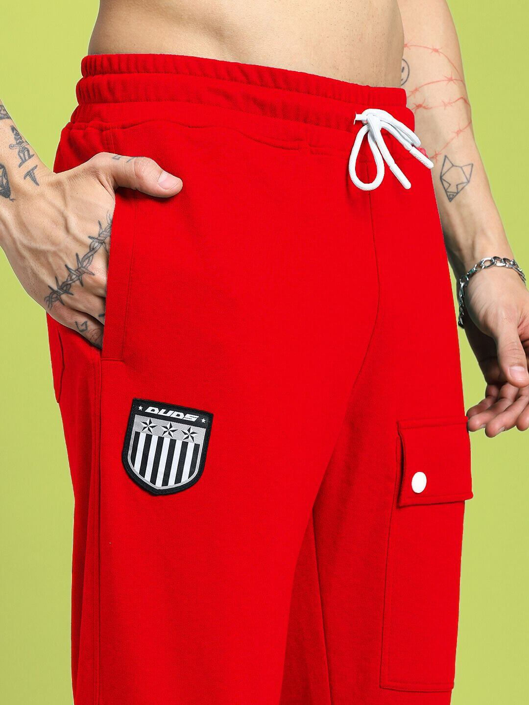 Model wearing AWESOME FLAP POCKET BAGGY JOGGER RED, highlighting the side pockets and bold red color, perfect for streetwear fashion.