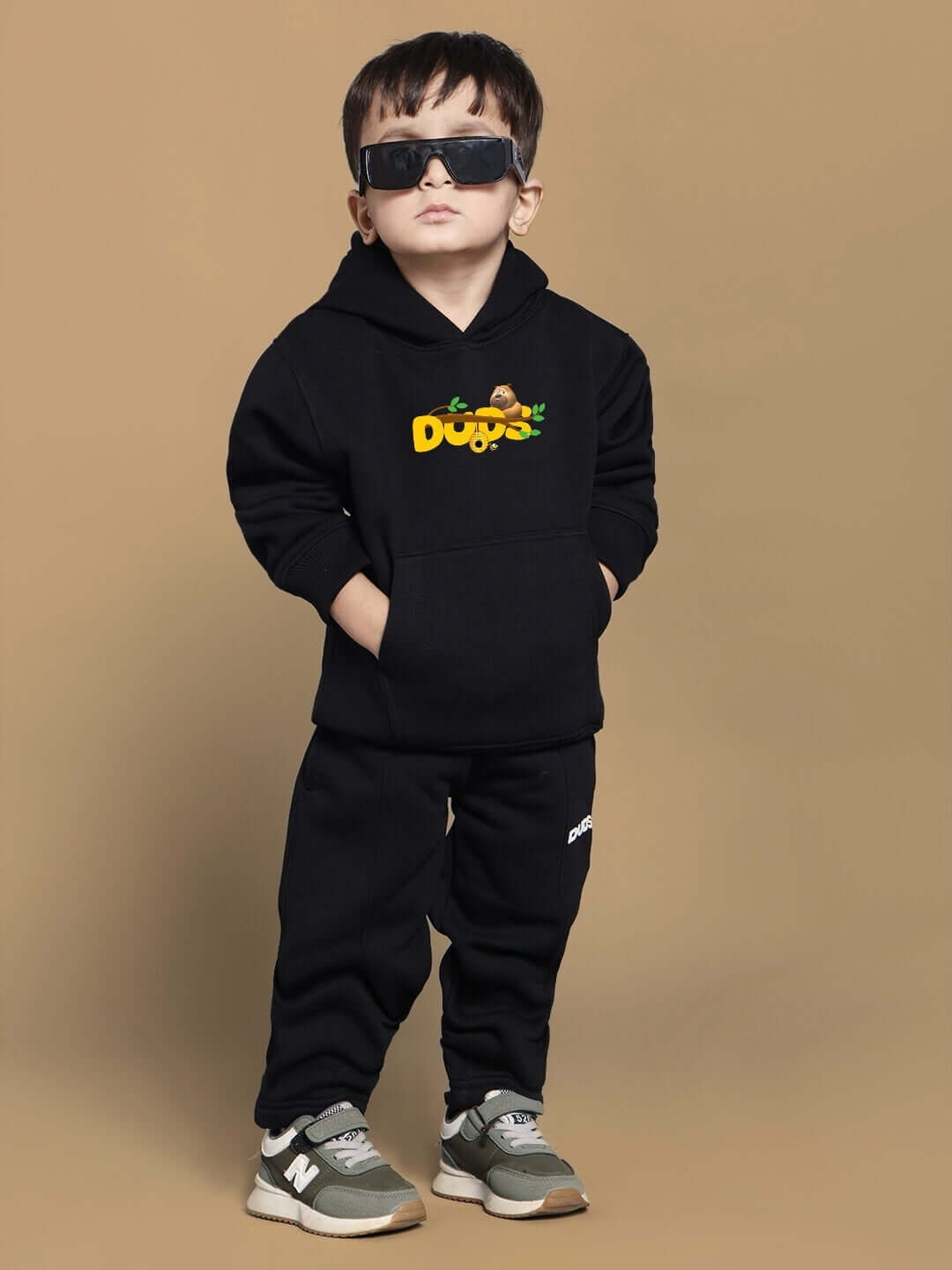 Child wearing black Bablu Dablu co-ord set for boys and girls with DUDS logo, featuring hooded sweatshirt and pants, stylish attire