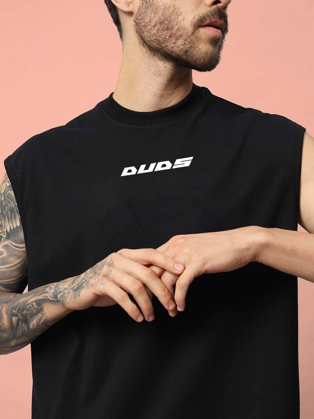 Man wearing a black Backbone Gym T-shirt by DUDS, featuring sleeveless design and logo, ideal for customization and comfort.